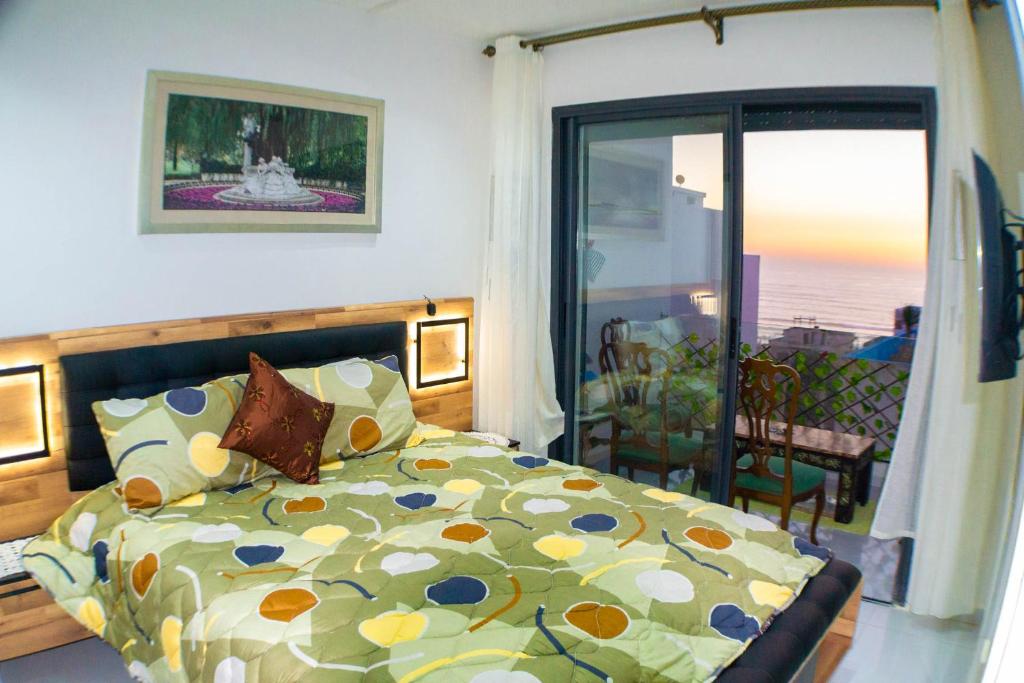- une chambre avec un lit et une porte coulissante en verre dans l'établissement appartement plage mahdia sable dor, à Kenitra