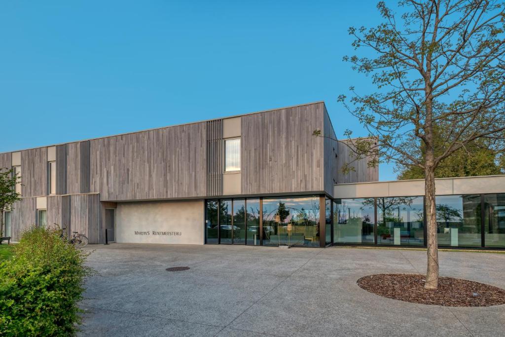 a building with a tree in front of it at Martin's Rentmeesterij in Bilzen