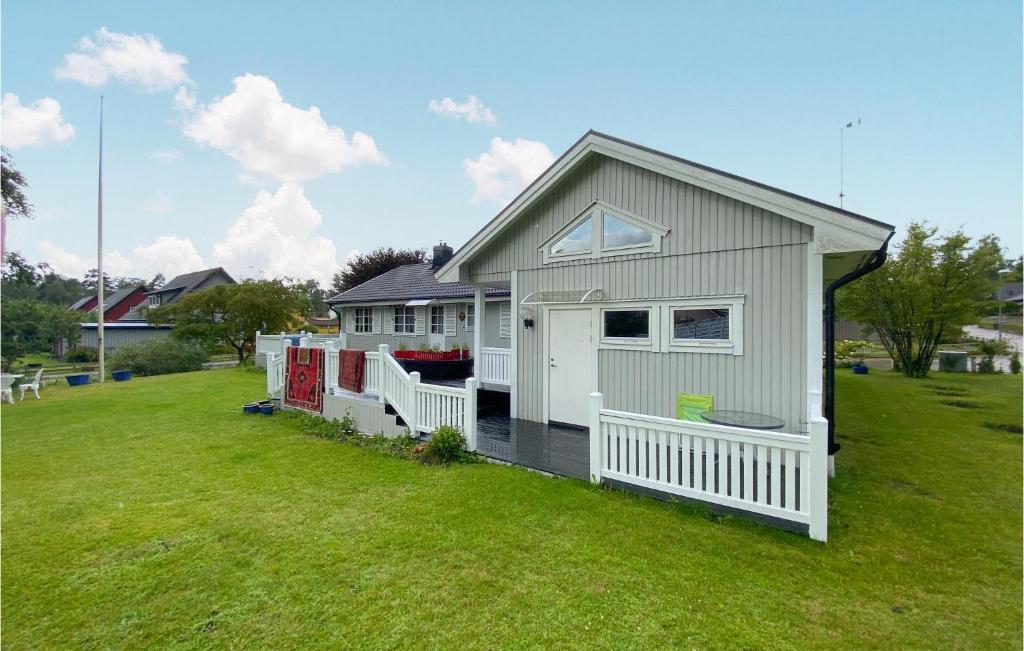 una pequeña casa blanca con una valla en un patio en Beautiful Apartment In Ljungby With Wifi And 1 Bedrooms, en Ljungby