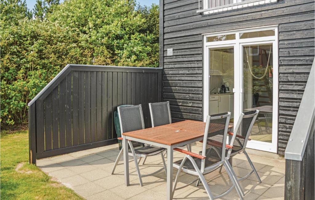 Une table et des chaises en bois sont disponibles sur la terrasse. dans l'établissement 2 Bedroom Stunning Apartment In Nrre Nebel, à Lønne Hede
