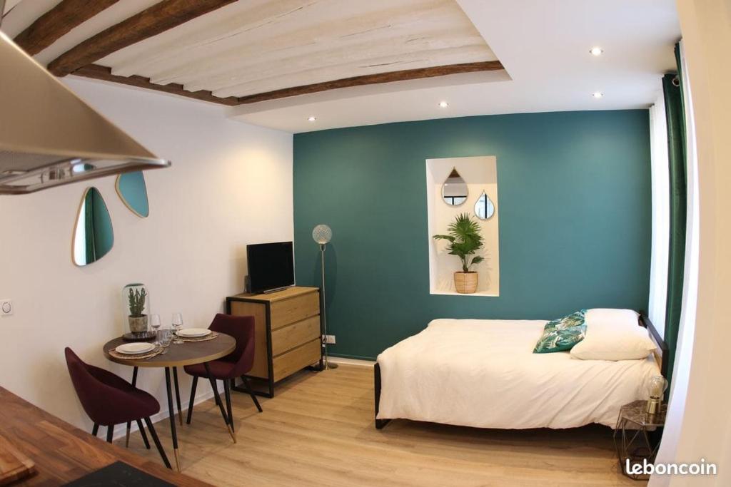 une chambre avec un lit, un bureau et une table dans l'établissement Charmant studio quartier Saint Louis à Versailles, à Versailles
