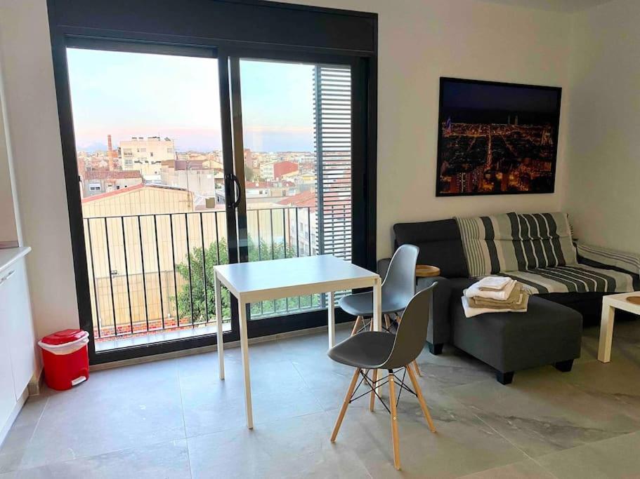a living room with a couch and a table with chairs at Modern Loft in Terrassa in Terrassa