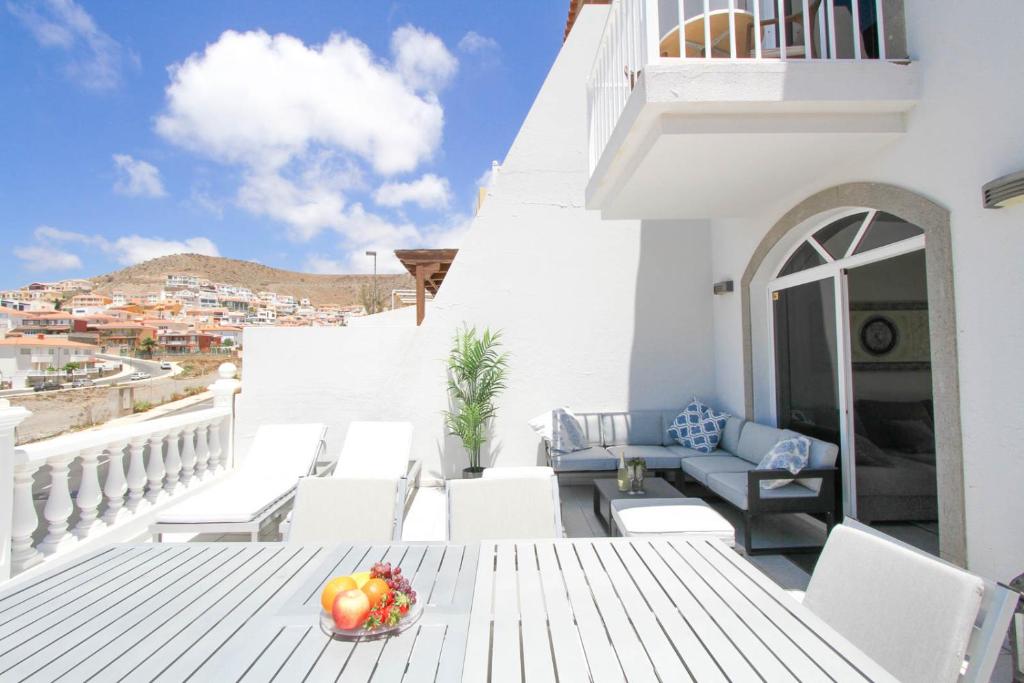 - une table et des chaises sur un balcon avec un bol de fruits dans l'établissement Casa grande familiar con 4 terrazas, à Las Palmas de Gran Canaria