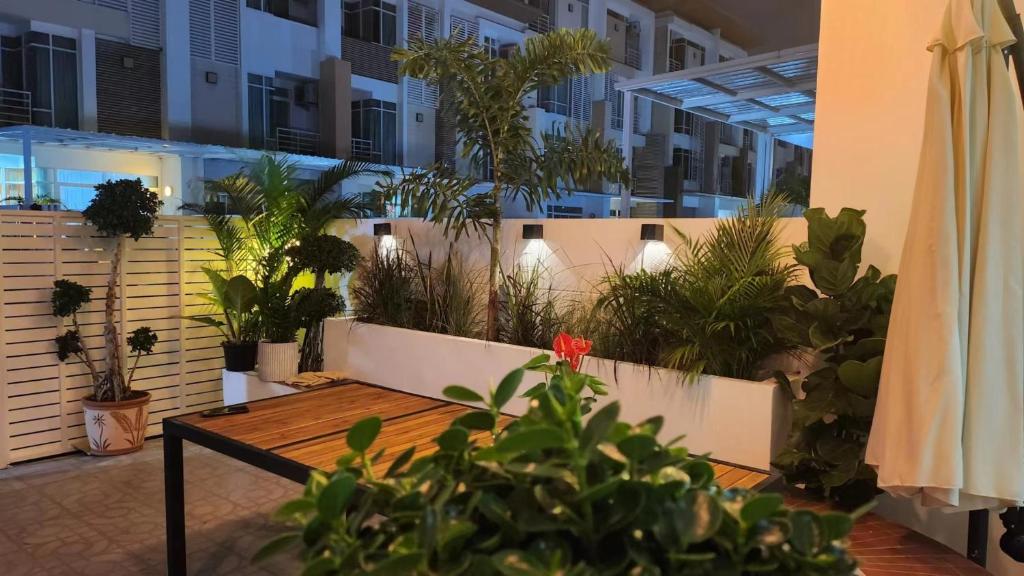 um pátio com plantas e uma mesa num edifício em Kann Villa Jomtien Beach & Yahaha em Praia de Jomtien