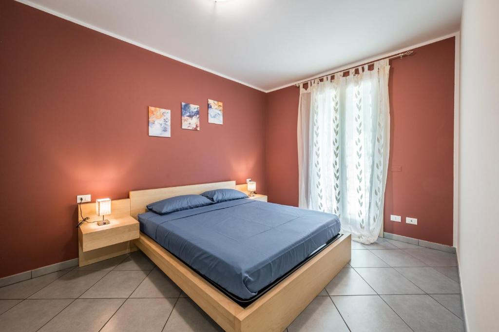 a bedroom with a blue bed and red walls at Ampio trilocale con giardino privato - Free WiFi & Private Parking in SantʼAgata sul Santerno