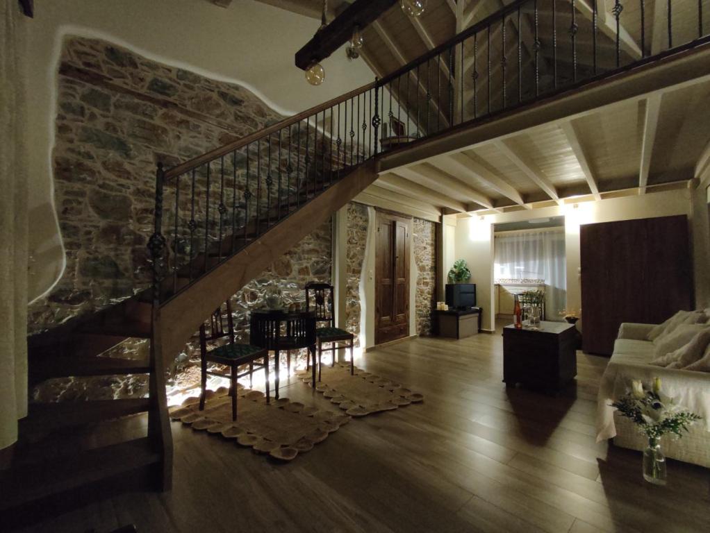 een woonkamer met een trap en een stenen muur bij Angel's Suites 2 in Samos