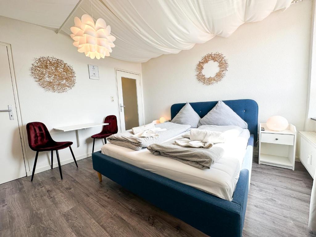a bedroom with a blue bed with two red chairs at Apartment für 3 Gäste mit kostenlosen Parkplätzen und Lift in Hannover