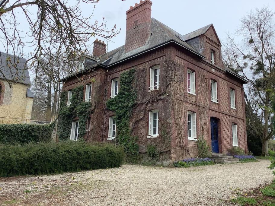 una vieja casa de ladrillo con hiedra creciendo en ella en Demeure XIXe Beauval-en-caux, 