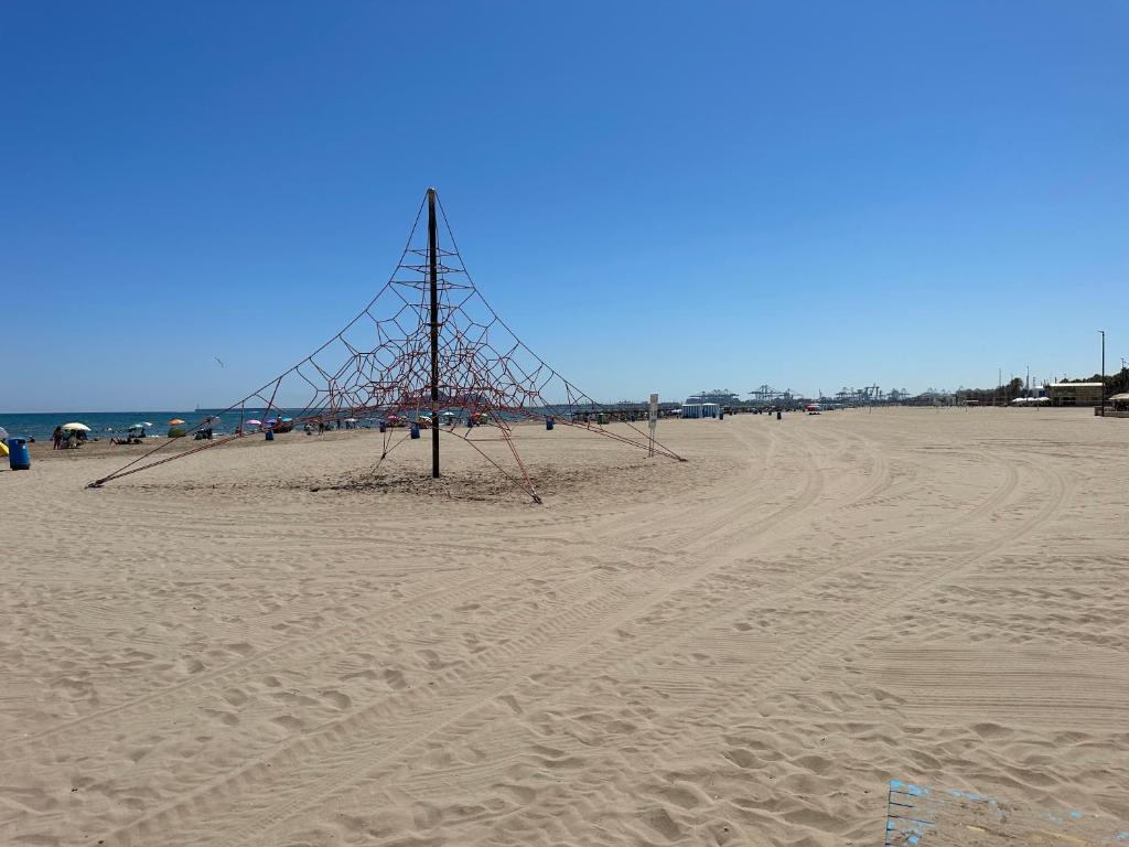 バレンシアにあるAlex Apartmentの海の隣の砂浜の柱