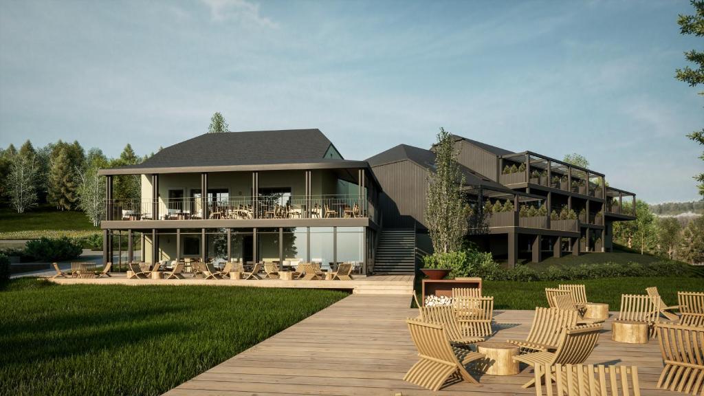 a house with a deck and chairs in front of it at Hillview Hotel Grandvoir in Neufchâteau