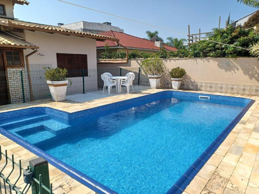 a swimming pool in front of a house at Excelente casa com piscina na Praia de Ingleses in Florianópolis