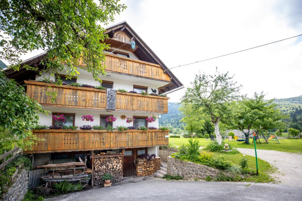 a house with wooden balconies and flowers on it at Apartmaji Verica Ceklin in Bohinj