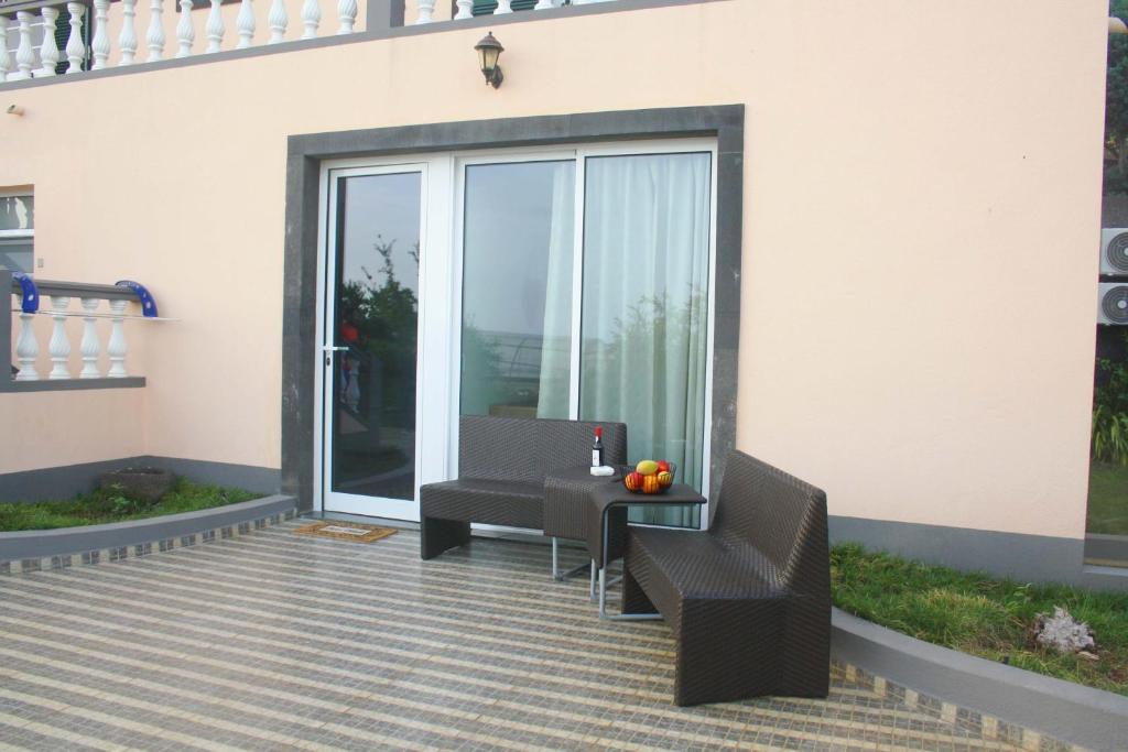 a patio with a table and chairs on a rug at Lugar dos Louros 2 in Estreito da Calheta