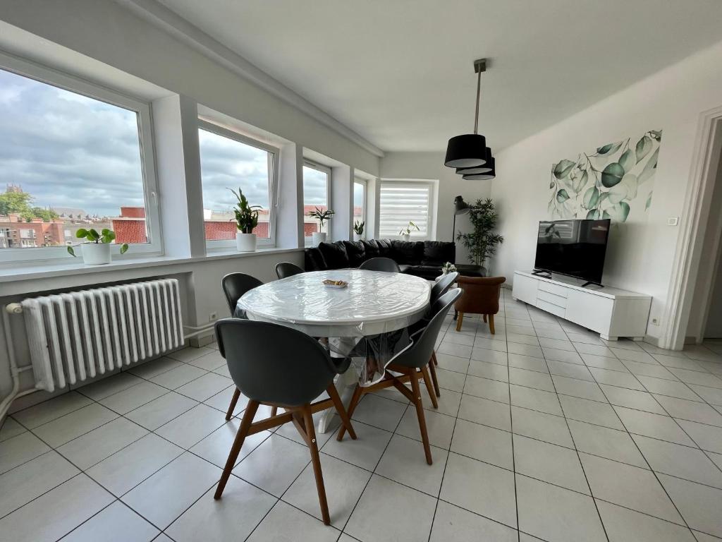 ein Wohnzimmer mit einem Tisch und Stühlen in der Unterkunft Appartement 6/8 pers Plage à 10min NETFLIX in Dunkerque