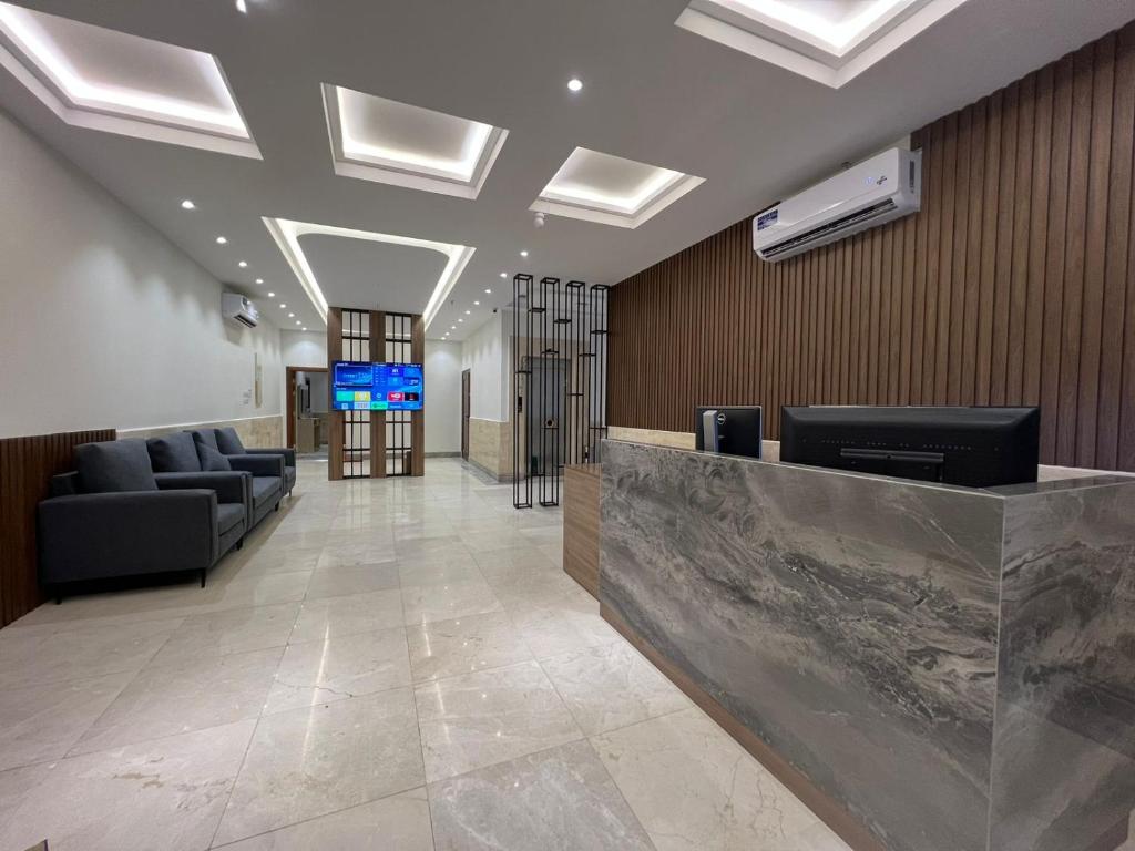 eine Lobby mit Sofas und eine Rezeption in einem Gebäude in der Unterkunft سويت إم للأجنحة الفندقية in Medina
