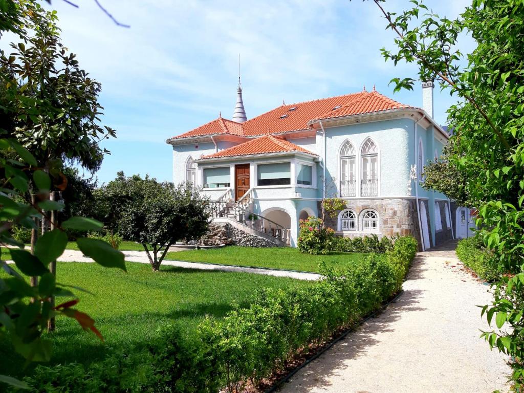 une grande maison blanche avec un toit rouge dans l'établissement Torres da Vila, à Anadia
