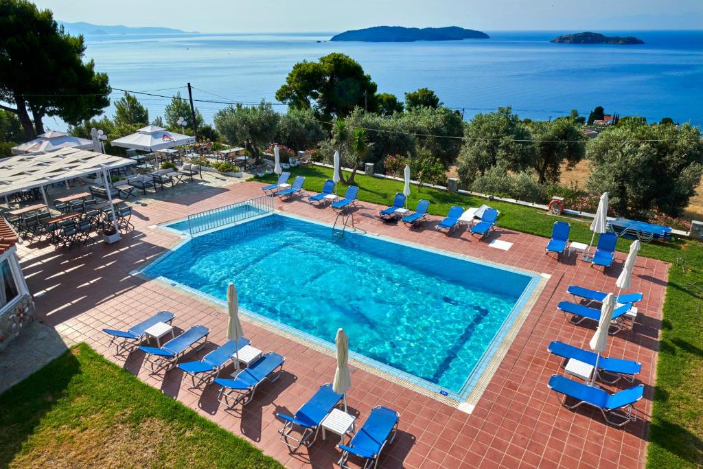 uma vista superior para uma piscina com espreguiçadeiras e para o oceano em agnadi hotel em Achladies