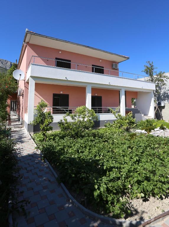 a pink house with bushes in front of it at Apartment Fila i Jure in Solin