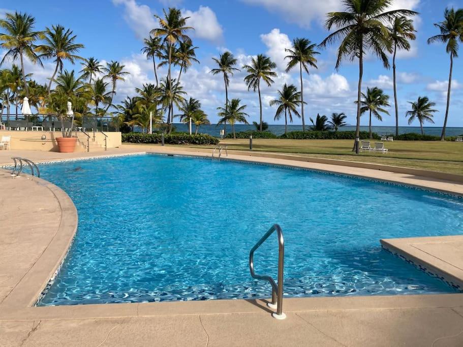 una gran piscina con palmeras en el fondo en BEACH ACCESS + 3 Pools + OCEAN VIEWS - 2BR In Palmas - Sleeps 7, en Humacao