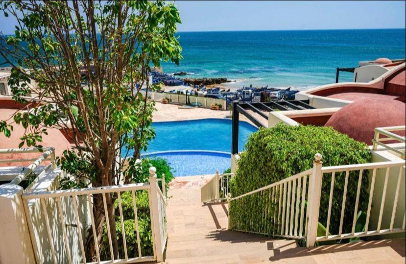 a resort with a swimming pool and the ocean at Triplex & Pool Tiguert in Agadir