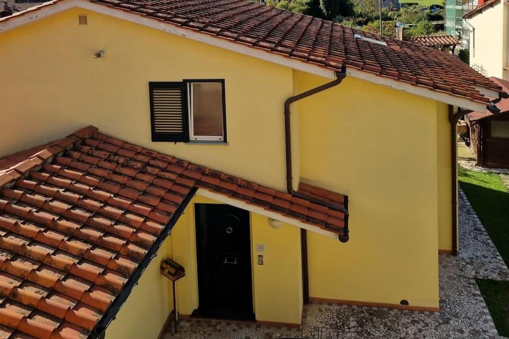 una casa amarilla con techo rojo en BarberinoRelax, en Barberino di Mugello