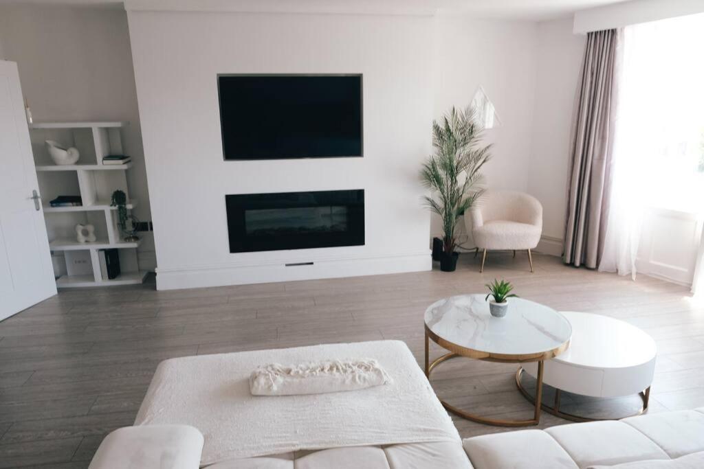 a living room with a white couch and a tv at Brighton Apartment by Pier in Brighton & Hove
