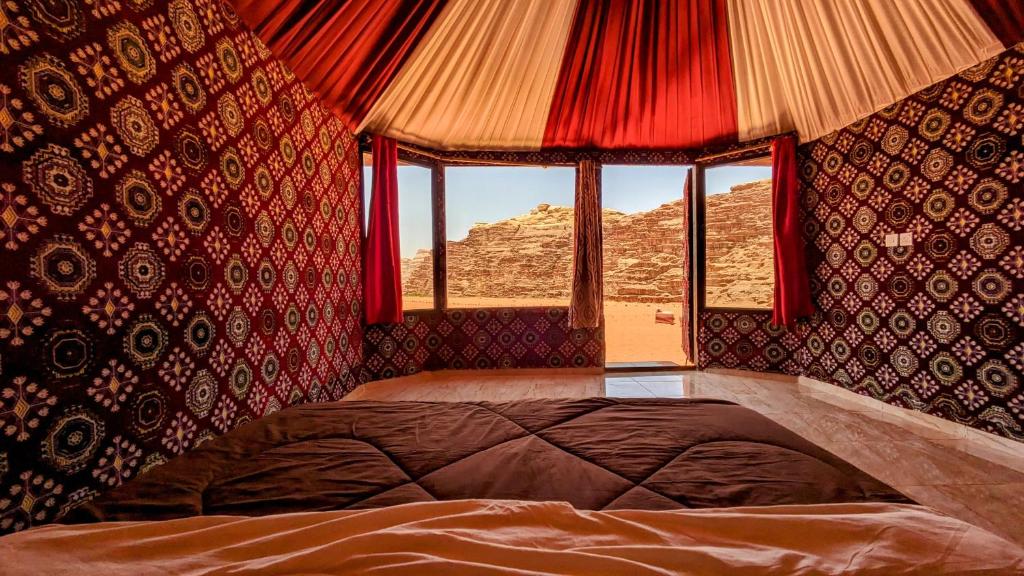Un dormitorio con una cama grande y una ventana en WhyDesert Camp & Tours, en Wadi Rum