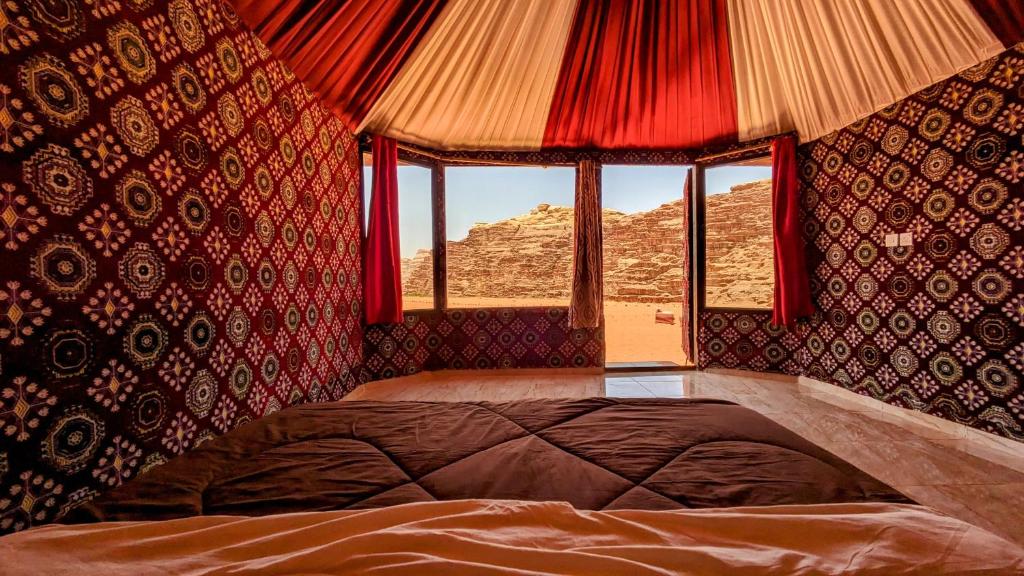 una camera da letto con un letto grande e una finestra di WhyDesert Camp & Tours a Wadi Rum