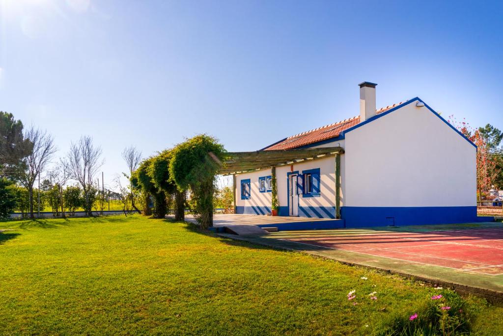 a small blue and white building with a tennis court at Quinta do Cutato - Beatriz Guest House - A1 in Santo Estêvão
