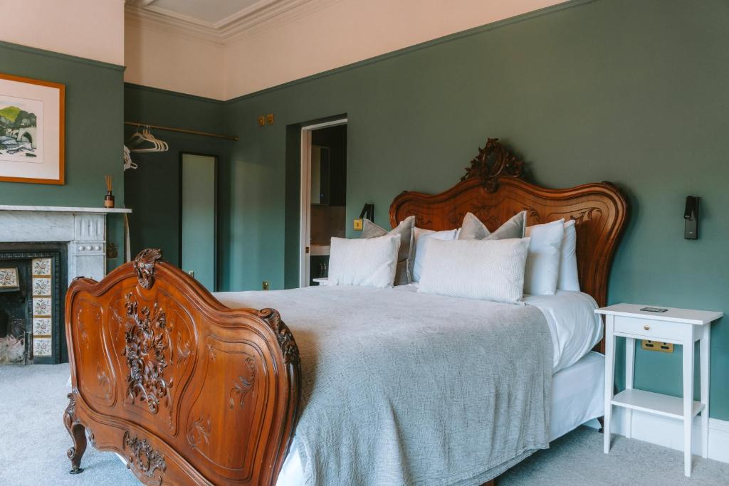 a bedroom with a large bed and a fireplace at Riversdale House Bed & Breakfast in Llangollen
