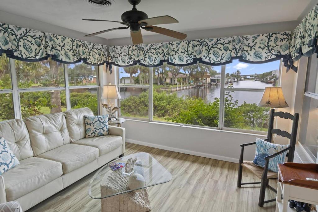 a living room with a white couch and a large window at Palm Paradise Waterfront Home - Flagler Beach - Dock - Pet Friendly - Close To The Beach in Flagler Beach