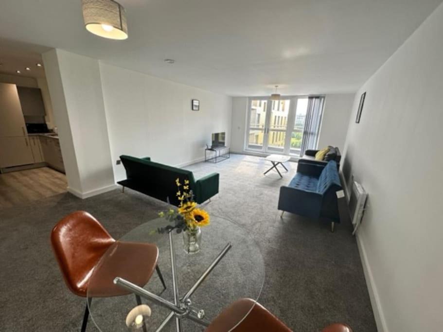 ein Wohnzimmer mit einem Sofa, einem Tisch und Stühlen in der Unterkunft XL 2 Bed Central MCR Apt Sleeps 7 in Manchester