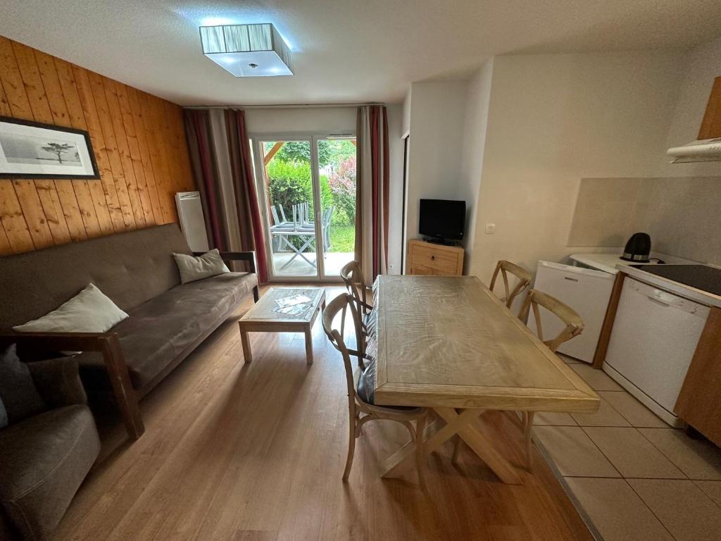 un soggiorno con un divano e un tavolo di Appartement T3 avec jardin et piscine - Luz Saint Sauveur, Val de Roland a Luz-Saint-Sauveur