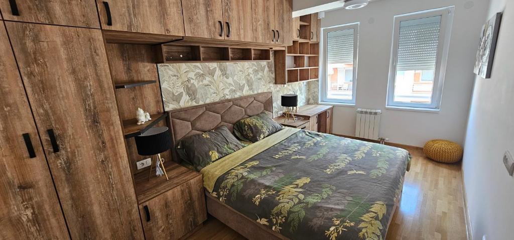 ein Schlafzimmer mit einem Bett mit einer Holzwand in der Unterkunft Kraljevački Lux parking GARAŽA in Kraljevo