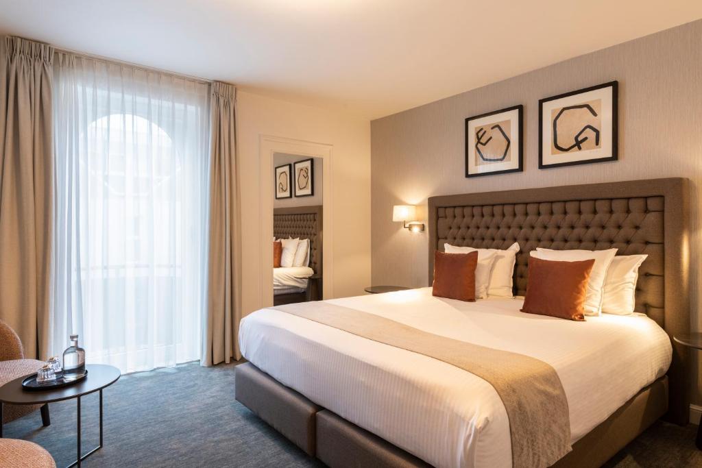 a hotel room with a large bed and a window at Dukes' Academie Brugge - by Dukes' Hotel Collection in Bruges