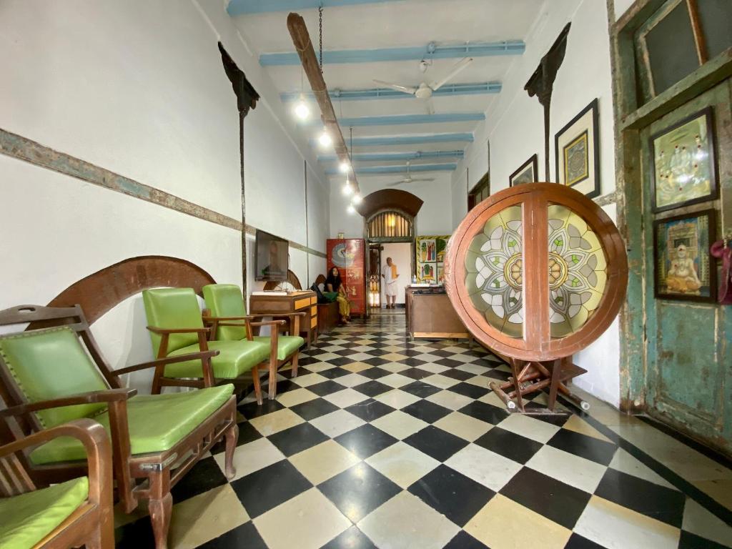 a waiting room with green chairs and a checkerboard floor at Hostel Vasantashram CST Mumbai in Mumbai