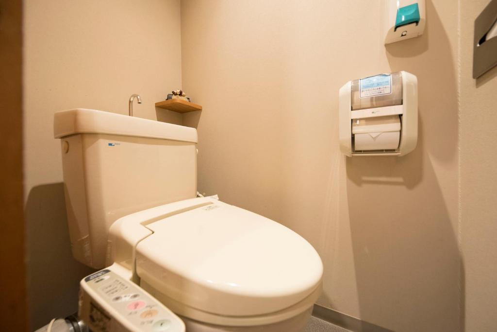 a bathroom with a white toilet in a room at Wafu-no-Yado MASUYA in Yamanouchi