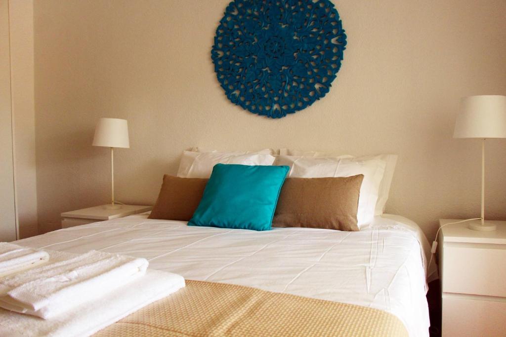 a bed with a blue pillow on top of it at Inncork Guesthouse in Ponte de Sor