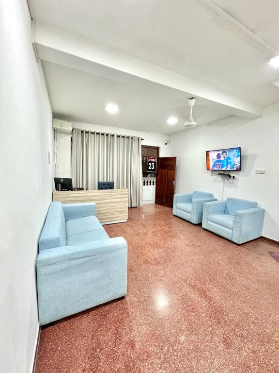 a living room with two blue couches and a flat screen tv at KINGS HOTEL in Colombo