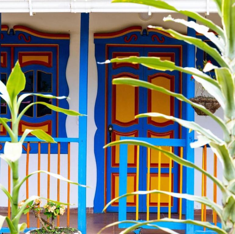 une porte d'entrée colorée d'une maison ornée de plantes dans l'établissement Posada Campestre Agua Bonita, à Pueblorrico