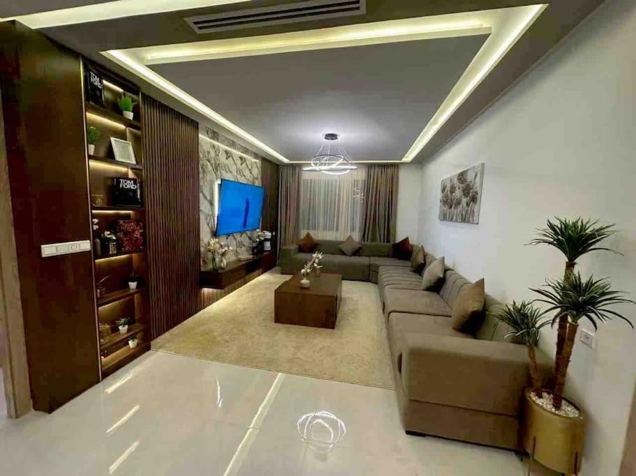 een woonkamer met een bank en een tv bij Appartement de Luxe à Tanger in Tanger