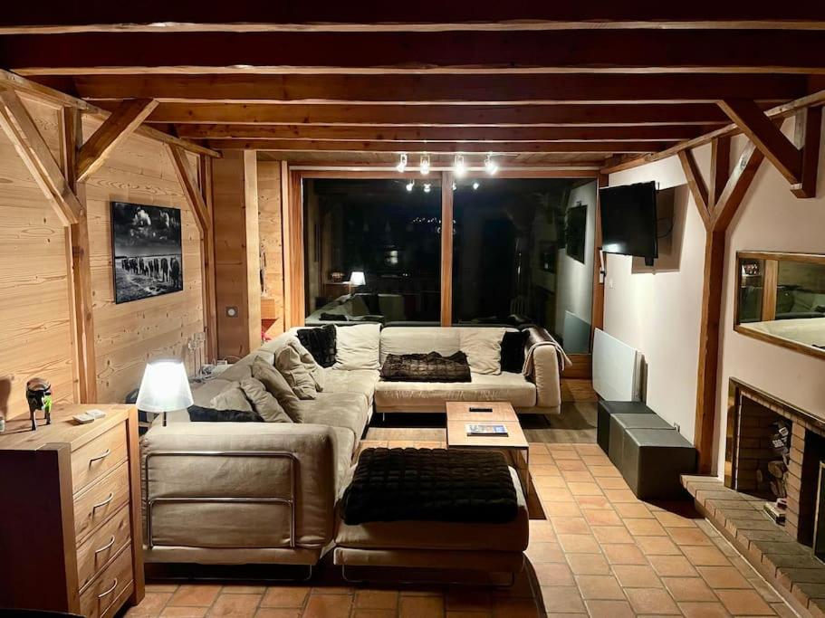 sala de estar con sofá y chimenea en Le Roc - Courchevel Village, en Courchevel