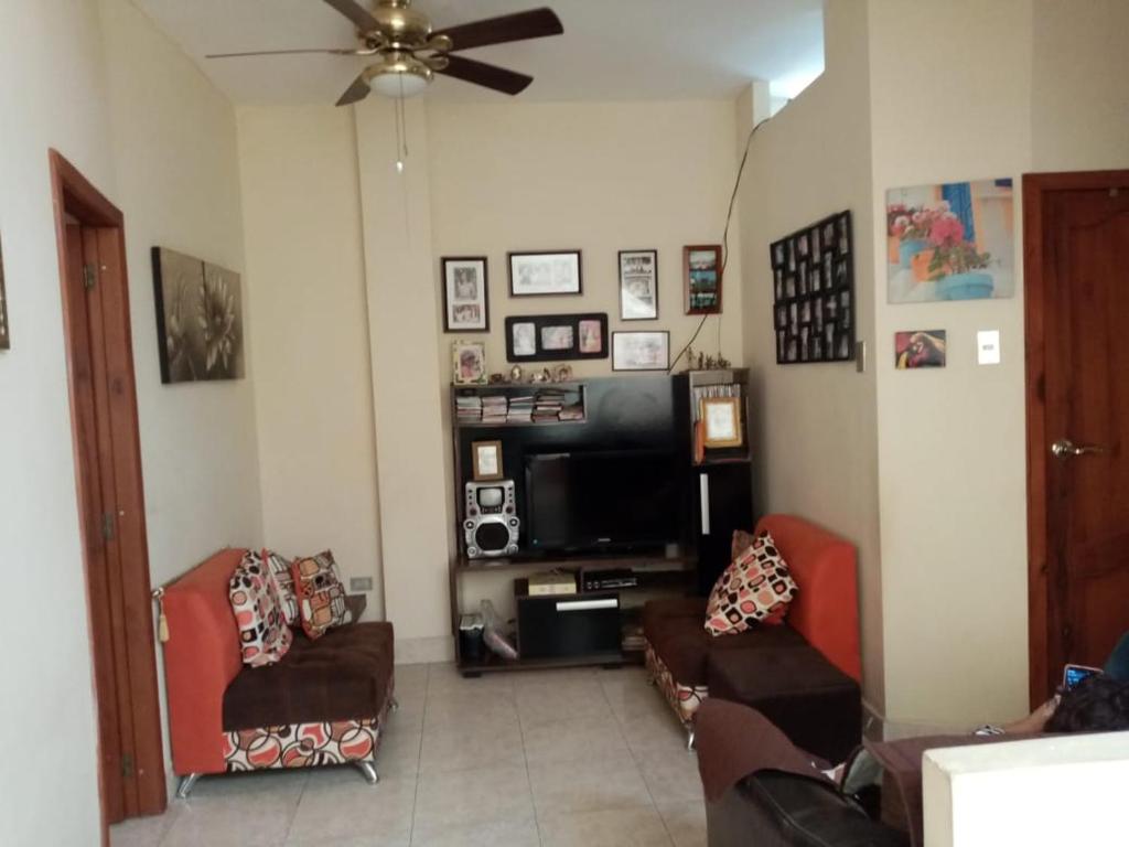 a living room with couches and a flat screen tv at Espacio familiar Poma in Machala