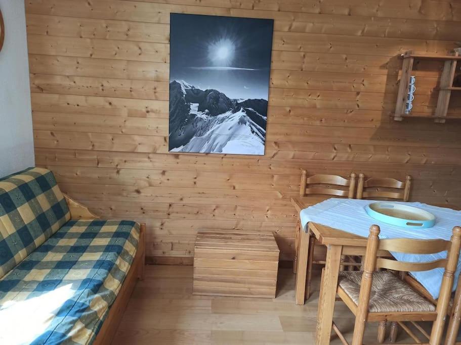 a room with a table and chairs in a wooden wall at Paradiski proches pistes et commerces vallandry in Landry