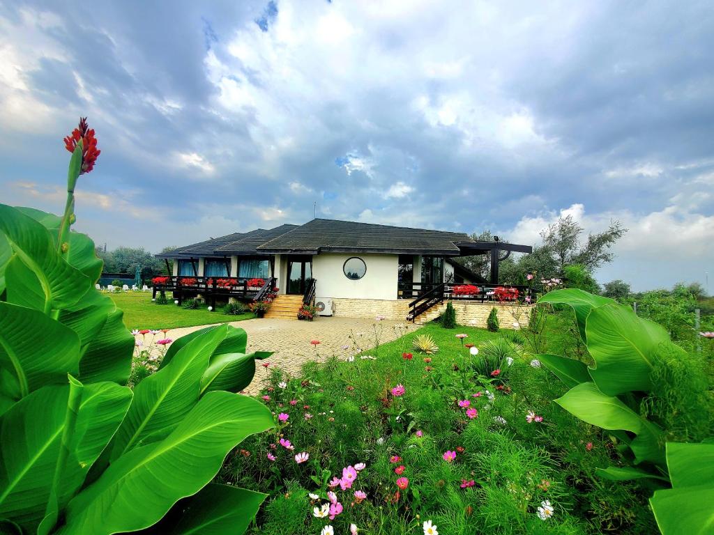 a house with a garden with flowers in front of it at Cirex Delta Club Sulina in Sulina