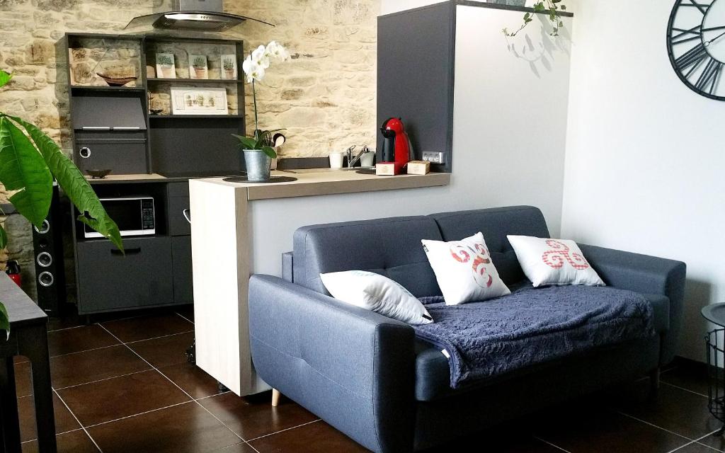 - un canapé bleu dans un salon avec une cuisine dans l'établissement LE P'TIT APPART, à Landerneau