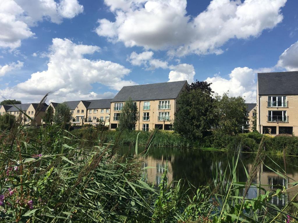 a row of apartment buildings next to a body of water at River Penthouse Little Paxton - 75 Skipper Way in Saint Neots