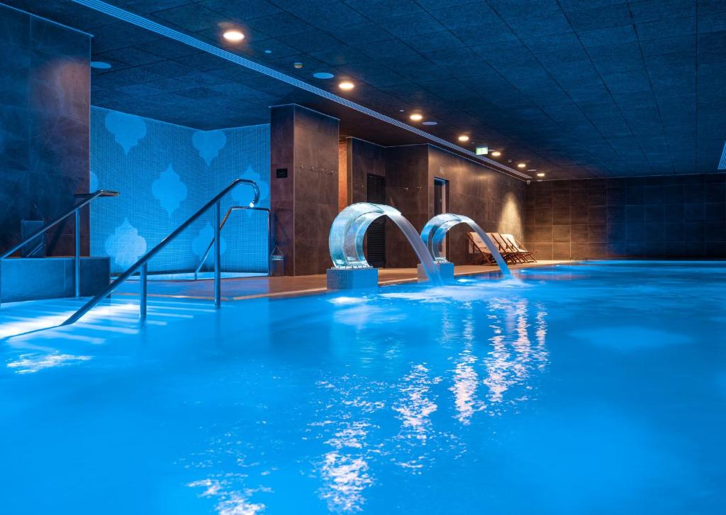 a swimming pool with blue water and slides at E1 Suites & Spa aparthotel style - Gym & Spa in Gibraltar