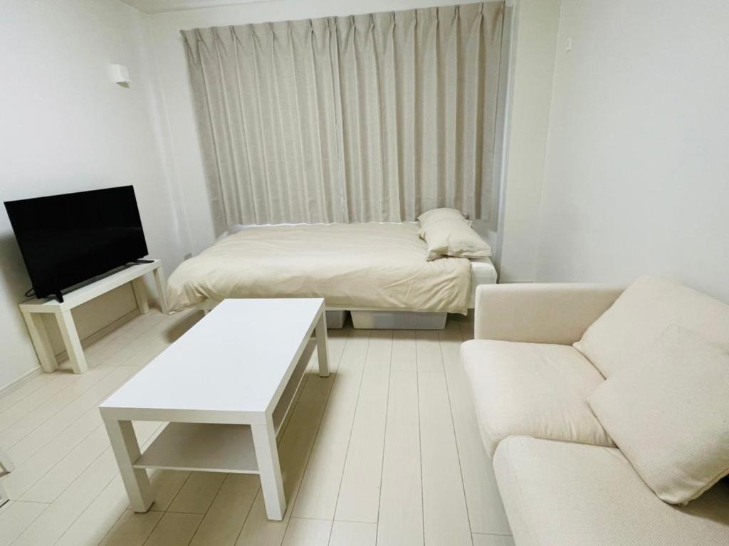 un piccolo soggiorno con divano e letto di STUDIO YONEGAHAMA l 米が浜通 a Yokosuka
