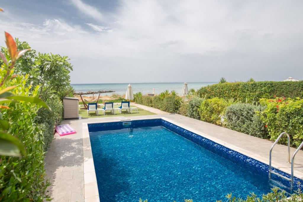 een zwembad met de oceaan op de achtergrond bij Villa Suri, Luxury Seafront Villa in Ayia Napa